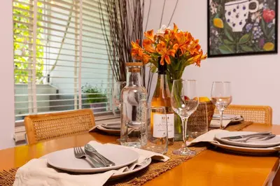 a table with plates and glasses and a vase of flowers at Spacious 2BR Apt Kremena 10 minutes walk to Center in Plovdiv