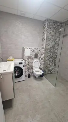 a bathroom with a toilet and a washing machine at Boho Style in Samokov