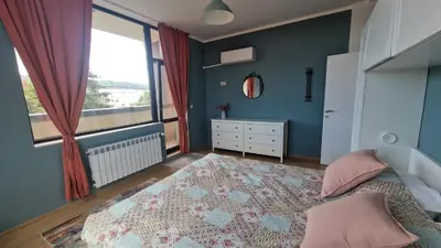 a bedroom with a bed and a large window at Boho Style in Samokov