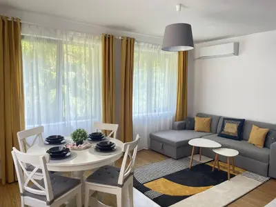 a living room with a table and a couch at Hrebet House in Borovets