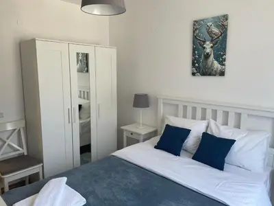 a bedroom with a bed with blue and white pillows at Hrebet House in Borovets