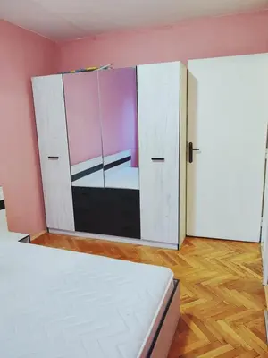 a bedroom with a bed and a mirror in a room at АПАРТАМЕНТ ДВЕ СТАИ ДО МЕТРОСТАНЦИЯ ВАРДАР Apartment In West Park near Subway in Sofia