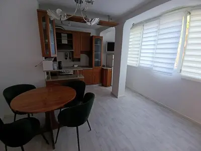 a kitchen and dining room with a table and chairs at АПАРТАМЕНТ ДВЕ СТАИ ДО МЕТРОСТАНЦИЯ ВАРДАР Apartment In West Park near Subway in Sofia