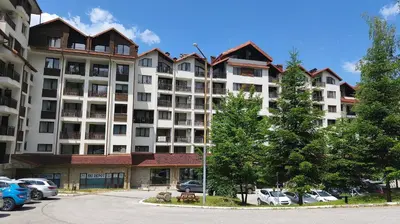a large apartment building with cars parked in a parking lot at Borovets Gardens Forest STUDIO A3 - FREE PARKING,Free baby cot in Borovets
