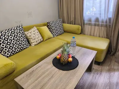 a living room with a yellow couch with a pineapple on a table at Borovets Gardens Forest STUDIO A3 - FREE PARKING,Free baby cot in Borovets