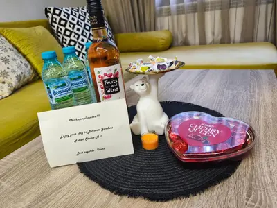 a table with a bottle of alcohol and a plate of food at Borovets Gardens Forest STUDIO A3 - FREE PARKING,Free baby cot in Borovets
