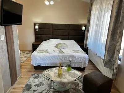 a bedroom with a bed with a table and a tv at Complex Koko Hills in Sapareva Banya