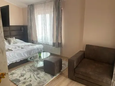 a bedroom with a bed and a chair and a glass table at Complex Koko Hills in Sapareva Banya