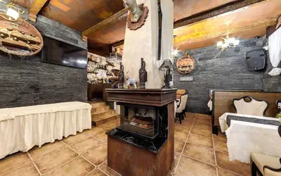 a living room with a fireplace and a dining room with tables at Complex Koko Hills in Sapareva Banya