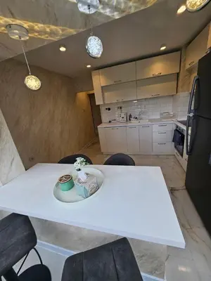a white table and chairs in a kitchen at Apartment Home in Troyan