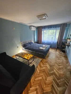 a living room with a bed and a couch at Apartment Home in Troyan