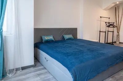 a bedroom with a large bed with a blue blanket at Sofia Downtown Apartment in Sofia