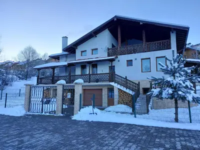 a large white house with snow on the ground at 19 Rose in Bansko