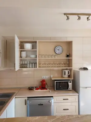 a kitchen with white appliances and a clock on the wall at 19 Rose in Bansko