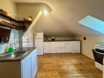 an attic kitchen with white cabinets and a white refrigerator at Quiet and Lovely 2 BDRM loft in the Old Centre in Sofia