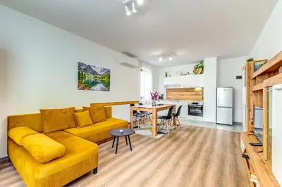 a living room with a yellow couch and a table at Villa Kometa - 1BD Apt with Balcony & Forest View by Flat Manager in Pamporovo