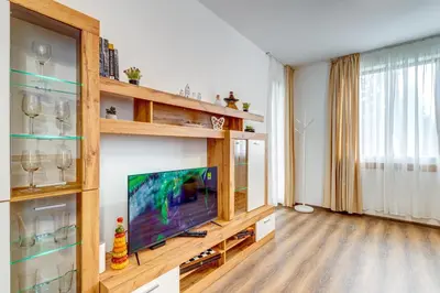 a living room with a flat screen tv on a wooden entertainment center at Villa Kometa - 1BD Apt with Balcony & Forest View by Flat Manager in Pamporovo