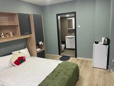 a bedroom with a large bed and a bathroom at GuestHouse Karma369 in Plovdiv