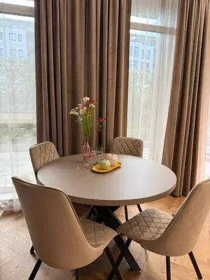 a table with chairs and a vase with flowers on it at The Giraffe's apartment in Sofia