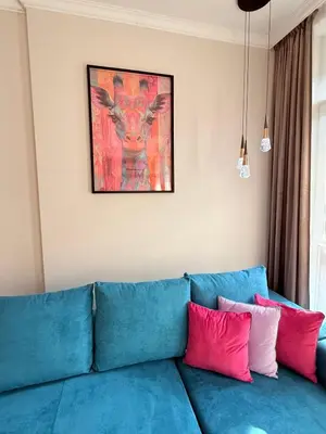 a blue couch with red and pink pillows on it at The Giraffe's apartment in Sofia