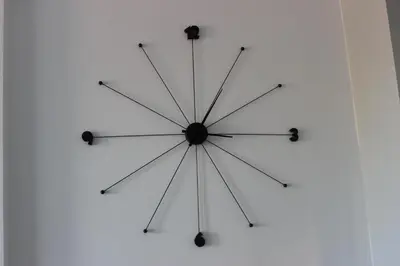 a large clock hanging on a white wall at Candy 26 Apartment in Velingrad