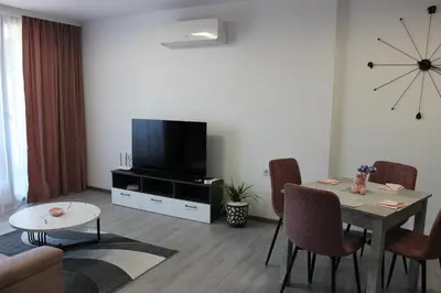 a living room with a table and a flat screen tv at Candy 26 Apartment in Velingrad