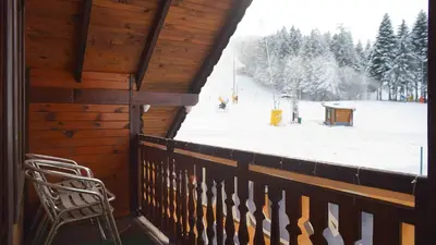 a room with a balcony with a snow covered slope at Complex Popangelov in Borovets