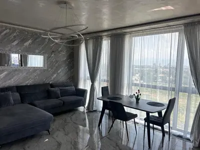 a living room with a couch and a table with chairs at Платинум 8 in Plovdiv
