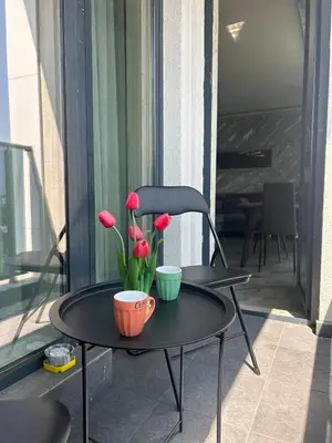 a table with two cups and flowers on a balcony at Платинум 8 in Plovdiv