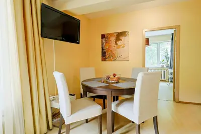 a dining room with a table and white chairs at My orchids apartment in the heart of Sofia in Sofia