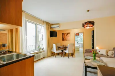 a kitchen and living room with a couch and a table at My orchids apartment in the heart of Sofia in Sofia