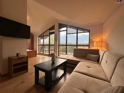 a living room with a couch and a table at Top floor and mountain views in Razlog