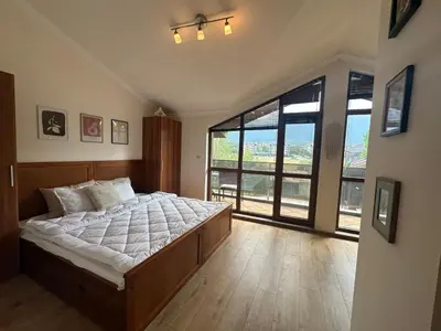 a bedroom with a large bed and a large window at Top floor and mountain views in Razlog