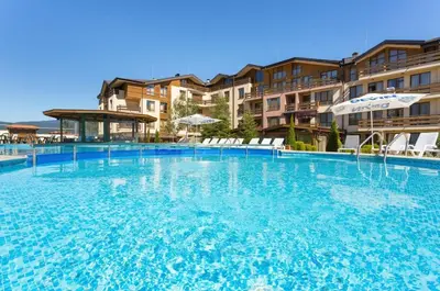 a large swimming pool with chairs and umbrellas at Top floor and mountain views in Razlog