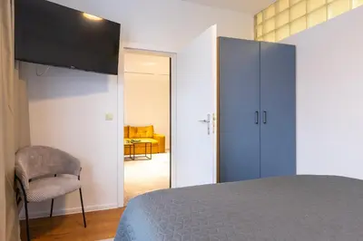 a bedroom with a blue cabinet and a chair at Mont Blanc Apartment in Bansko