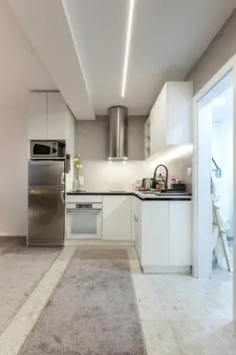 a kitchen with white cabinets and stainless steel appliances at Mont Blanc Apartment in Bansko