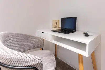 a white desk with a laptop and a chair at Mont Blanc Apartment in Bansko