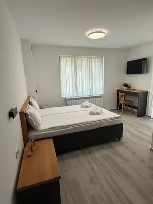 a bedroom with a large bed and a desk at Gorna Banya luxury apartments in Sofia