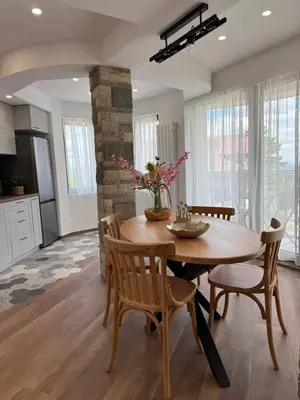 a kitchen and dining room with a wooden table and chairs at Gorna Banya luxury apartments in Sofia