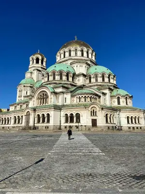 a large building with a person standing in front of it at Spacious 1BR Apartment in Central Sofia, Next to University in Sofia