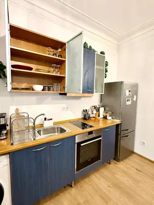 a kitchen with blue cabinets and a stainless steel refrigerator at Spacious 1BR Apartment in Central Sofia, Next to University in Sofia