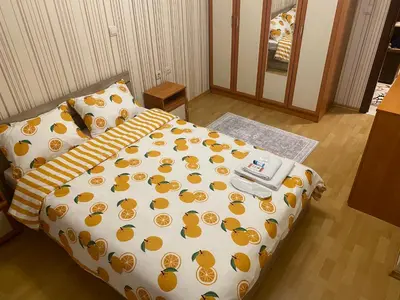 a bedroom with a bed with a yellow and orange comforter at Pirin 7 in Pazardzhik
