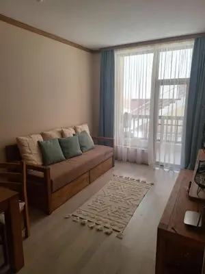 a living room with a couch and a large window at Ego apartment Velingrad in Velingrad