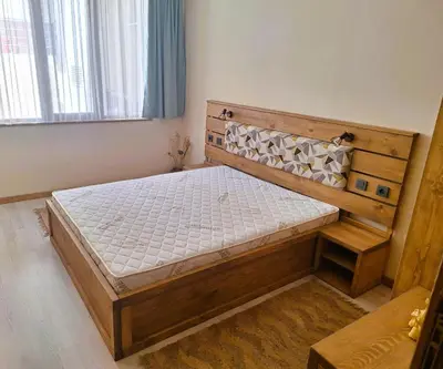 a bedroom with a wooden bed in a room at Ego apartment Velingrad in Velingrad