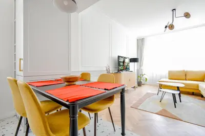 a dining room with a table and yellow chairs at Stylish 2BD with Balcony & Desk near Vitosha Blvd by Flat Mаnager in Sofia