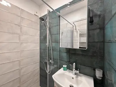a bathroom with a sink and a shower at Stylish 2BD with Balcony & Desk near Vitosha Blvd by Flat Mаnager in Sofia