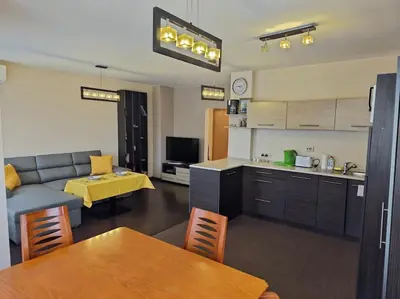 a kitchen and a living room with a couch and a table at Bright and spacious apartment with panoramic views in Sofia