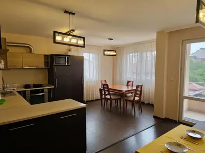 a kitchen and dining room with a table and chairs at Bright and spacious apartment with panoramic views in Sofia