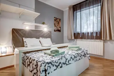 a bedroom with a large white bed with green towels on it at San Stefano 4 Free Parking 2 BRDM 100m Zaimov Park in Sofia