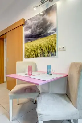 a pink table with two chairs and a painting on the wall at San Stefano 4 Free Parking 2 BRDM 100m Zaimov Park in Sofia